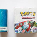 A box of pokemon cards next to another card.